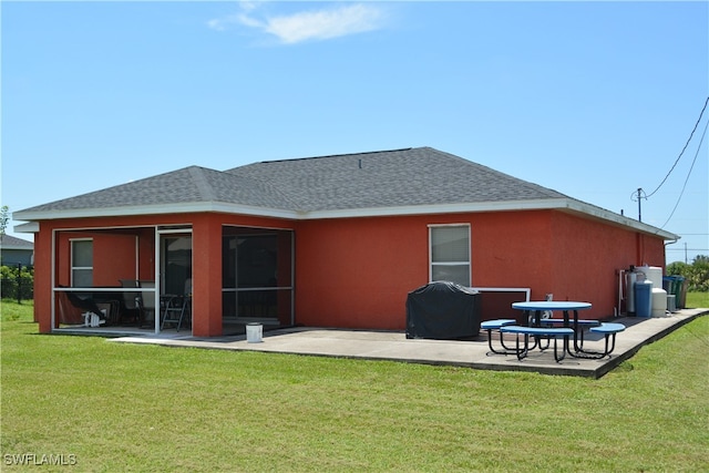 back of house featuring a lawn and a patio