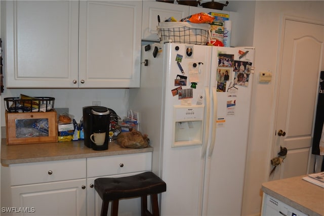 kitchen featuring white fridge with ice dispenser and white cabinetry