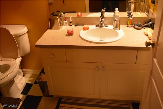 bathroom featuring vanity, tile patterned flooring, and toilet