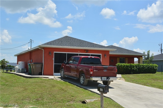 view of front of house featuring a front lawn and a garage