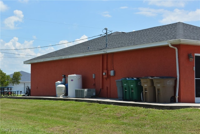 back of house with a lawn and cooling unit