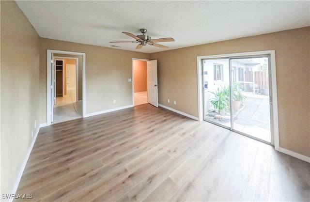 unfurnished bedroom with access to outside, a textured ceiling, ceiling fan, and hardwood / wood-style flooring