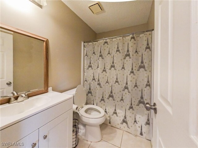 bathroom with a textured ceiling, vanity, tile patterned flooring, and toilet