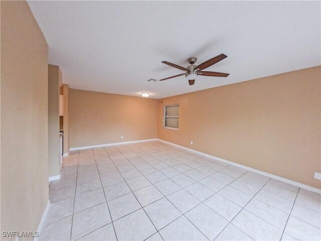 tiled spare room with ceiling fan