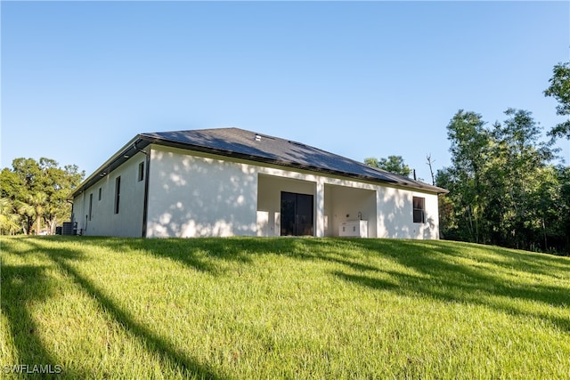 rear view of property featuring a lawn and central AC