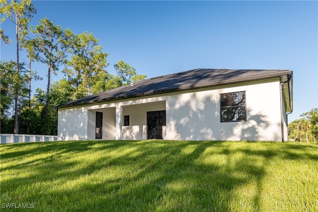 rear view of house featuring a lawn