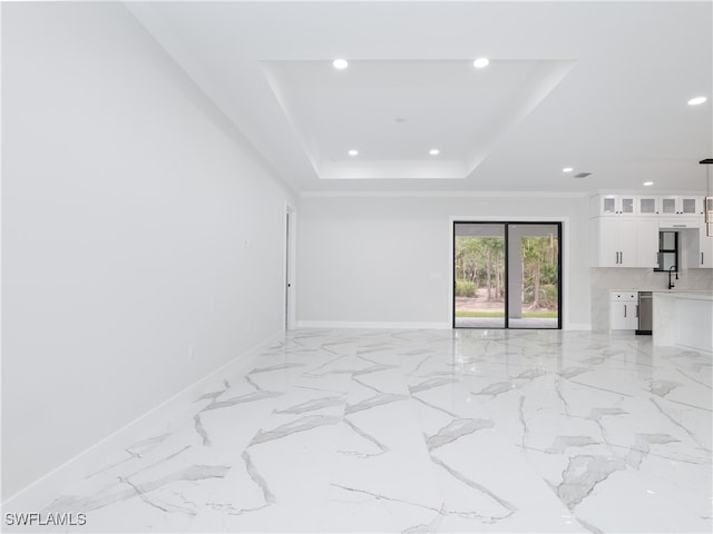 spare room featuring a tray ceiling and sink