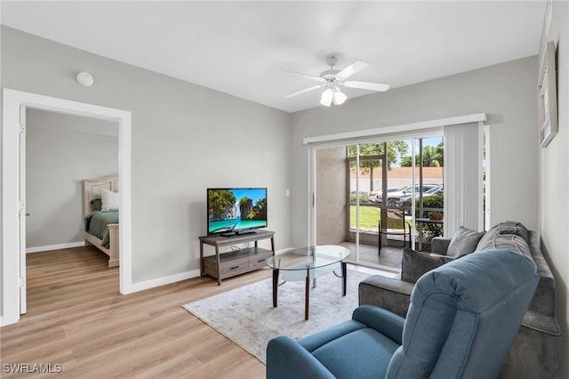 living area featuring light wood-type flooring, a ceiling fan, and baseboards