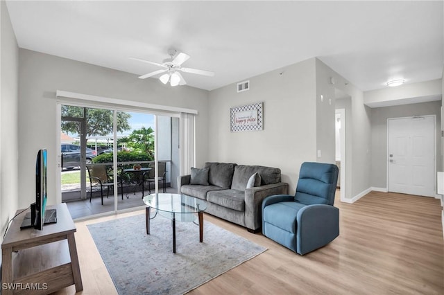 living area featuring light wood finished floors, baseboards, visible vents, and ceiling fan