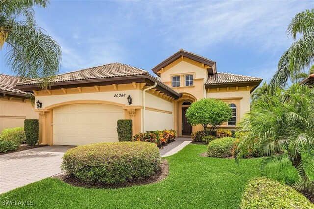 mediterranean / spanish home with a front lawn and a garage