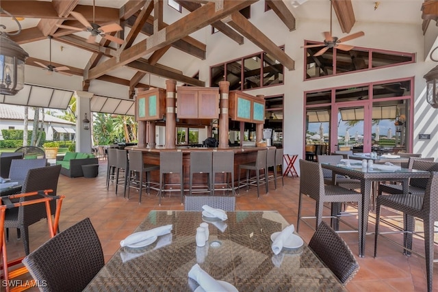 dining space with ceiling fan, high vaulted ceiling, and light tile patterned floors