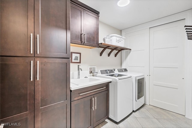 laundry area with sink, light tile patterned floors, cabinets, and washer and dryer