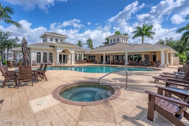 view of pool featuring a hot tub and a patio area