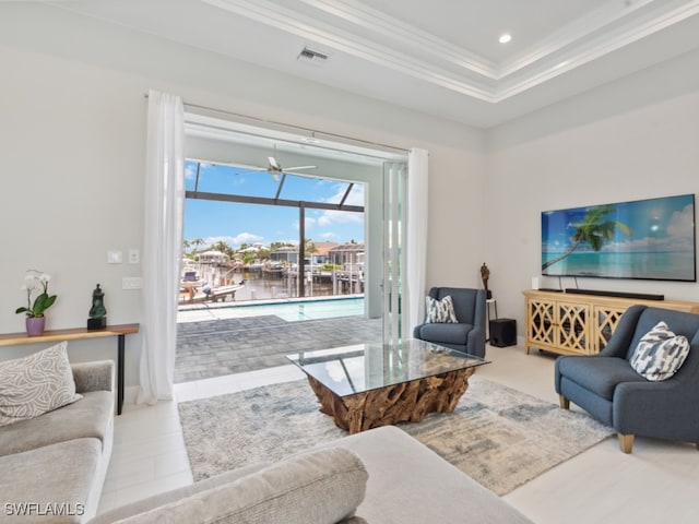 living room featuring ceiling fan, a raised ceiling, and light tile patterned floors