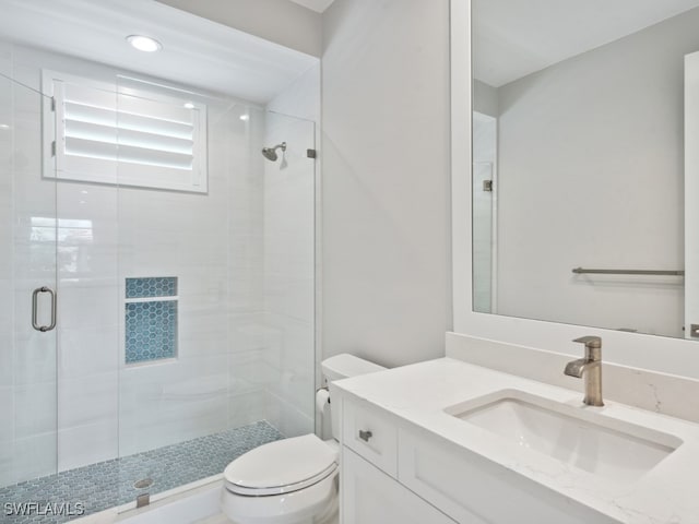 bathroom with an enclosed shower, toilet, and vanity