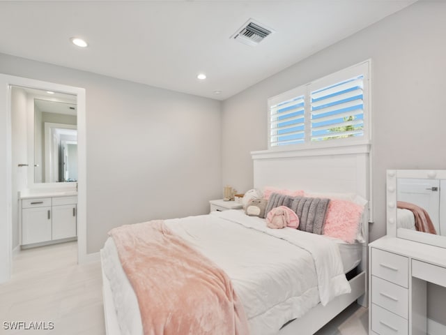 bedroom featuring connected bathroom and light hardwood / wood-style flooring