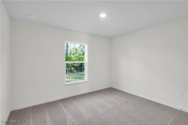 carpeted empty room featuring baseboards