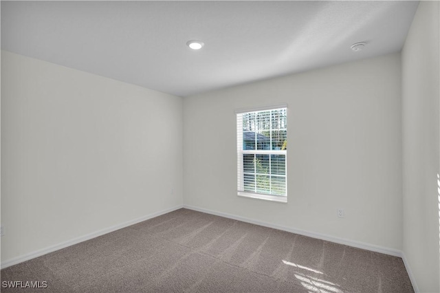 unfurnished room with carpet and baseboards