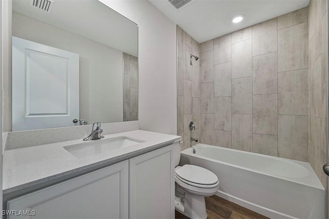 2701 NW 21st Ter, Cape Coral, FL 33993 - bathroom featuring wood finished floors, toilet, vanity, and tub / shower combination