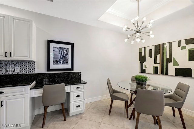 dining space with light tile patterned flooring, a notable chandelier, and a raised ceiling