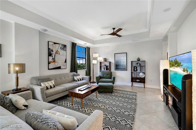 tiled living room with a tray ceiling and ceiling fan