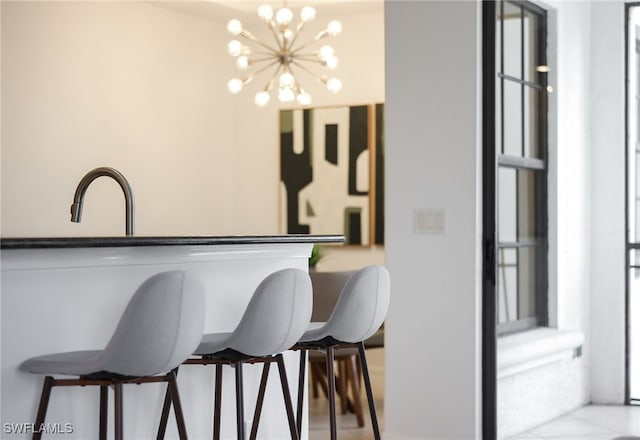 kitchen with a kitchen bar, hanging light fixtures, and a notable chandelier