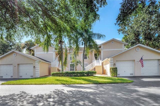 737 Wiggins Lake Dr Unit 201, Naples, FL 34110 - view of front of house featuring stucco siding, stairs, a front lawn, and an attached garage