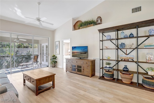 living room featuring ceiling fan, french doors, high vaulted ceiling, and light hardwood / wood-style floors