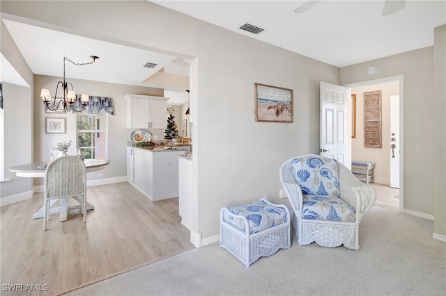 sitting room with a notable chandelier and light hardwood / wood-style floors