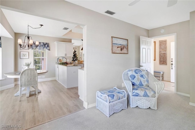 737 Wiggins Lake Dr Unit 201, Naples, FL 34110 - living area featuring a chandelier, baseboards, ceiling fan, and light wood-type flooring