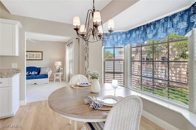 737 Wiggins Lake Dr Unit 201, Naples, FL 34110 - dining space with a chandelier, light wood finished floors, plenty of natural light, and baseboards