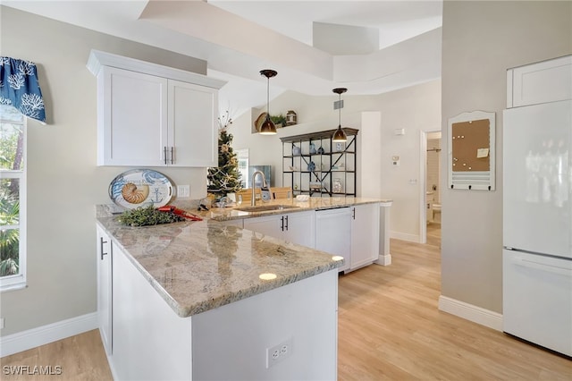 kitchen featuring white cabinetry, white appliances, kitchen peninsula, and sink