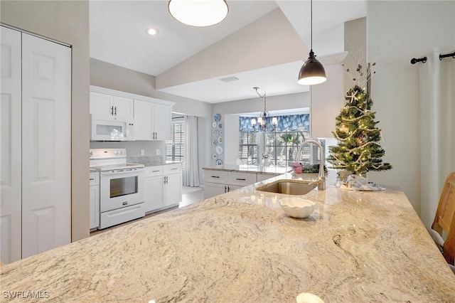 kitchen featuring sink, pendant lighting, lofted ceiling, white appliances, and white cabinets