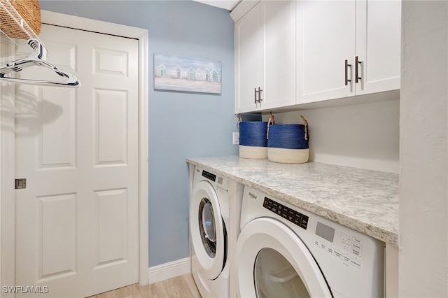 laundry area featuring cabinets, light hardwood / wood-style flooring, and washer and dryer