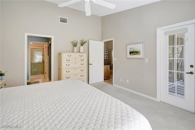 carpeted bedroom with ceiling fan, a towering ceiling, and ensuite bathroom