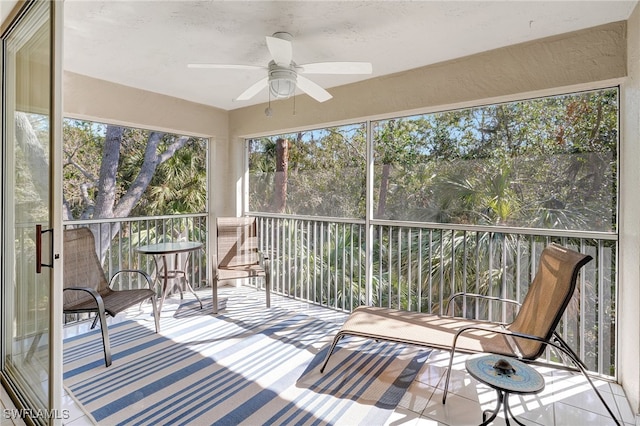 unfurnished sunroom with ceiling fan