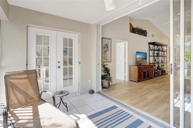 interior space featuring french doors, light hardwood / wood-style floors, and vaulted ceiling