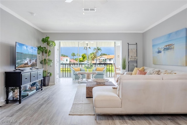 living room with hardwood / wood-style floors, ceiling fan, and crown molding