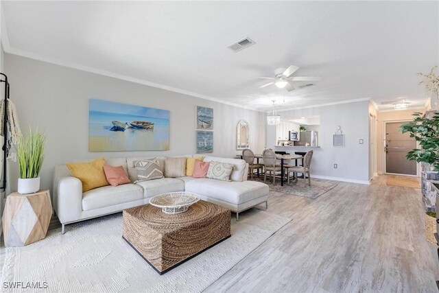 living room with hardwood / wood-style flooring, ceiling fan, and ornamental molding