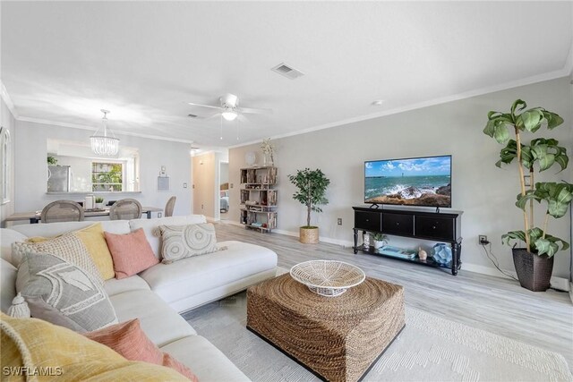 living room with ceiling fan with notable chandelier, light hardwood / wood-style flooring, and ornamental molding