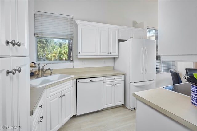 kitchen featuring white cabinetry, plenty of natural light, and white appliances