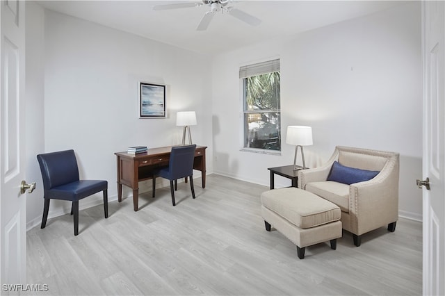 home office with light hardwood / wood-style floors and ceiling fan