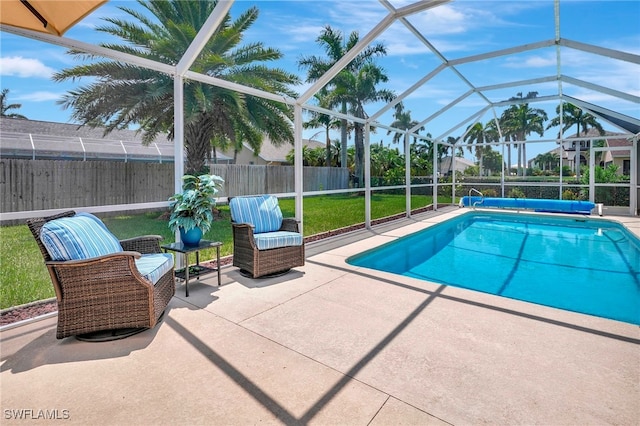 view of swimming pool featuring a lawn, glass enclosure, and a patio