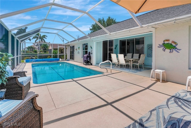 view of pool featuring glass enclosure and a patio area