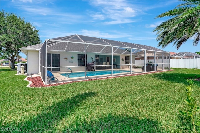 back of house featuring glass enclosure, a fenced in pool, and a yard