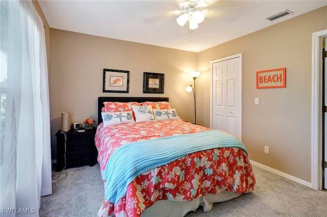 bedroom with a closet, ceiling fan, and light colored carpet