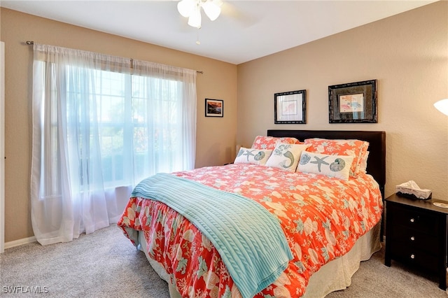 bedroom with ceiling fan and light carpet