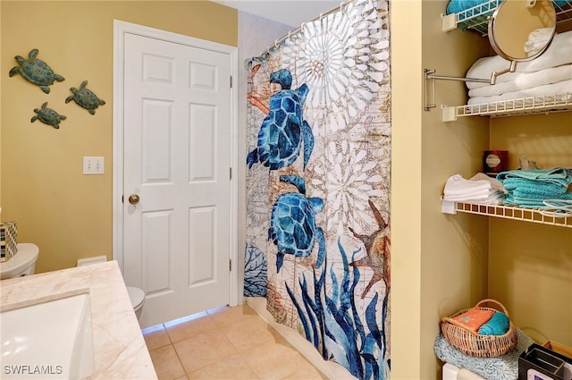 bathroom with sink, toilet, and tile patterned floors