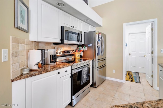 kitchen with backsplash, stainless steel appliances, white cabinetry, and light tile patterned floors