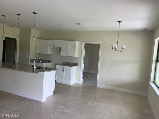 kitchen with sink, dark stone counters, white cabinetry, and light tile patterned floors